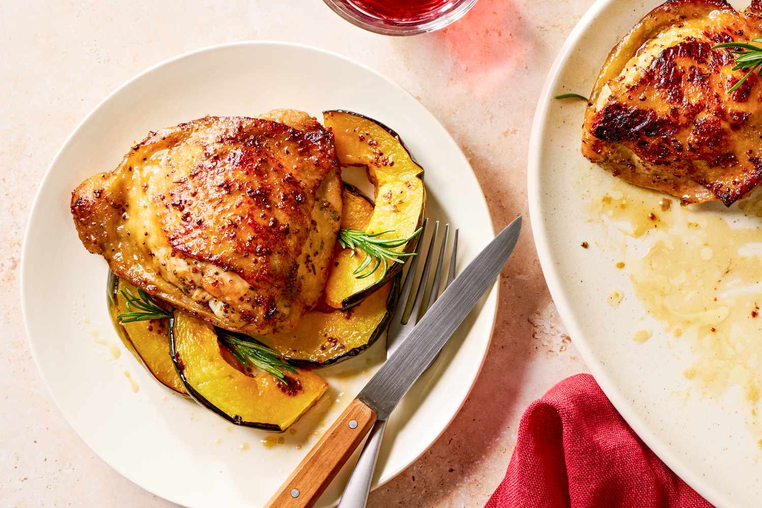 Vue de haut d'une assiette blanche contenant une portion de poulet glacé à l'érable et de courge avec une fourchette et un couteau