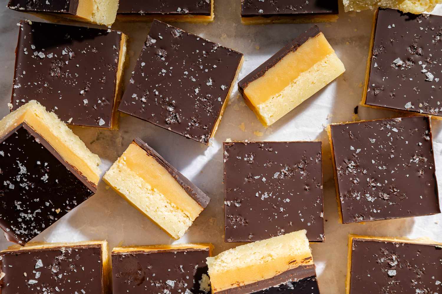 Vue de dessus de plusieurs barres de Millionaire Shortbread sur du papier sulfurisé