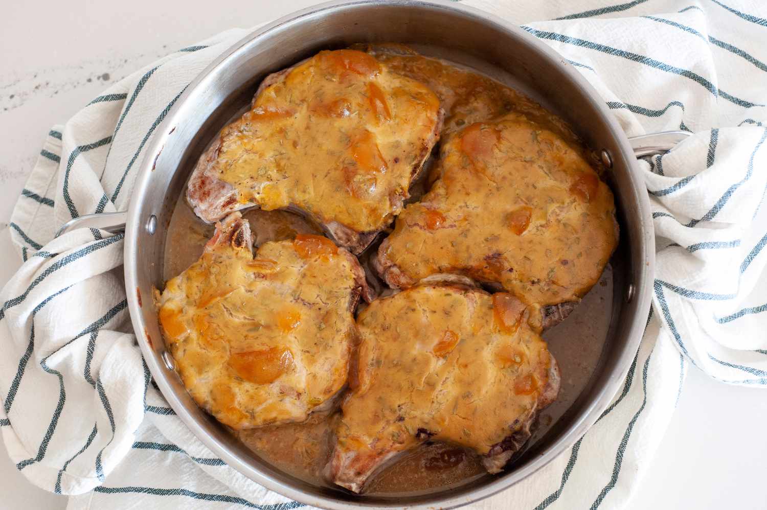 Côtelettes de porc à la moutarde de pêche dans une poêle sur un torchon de cuisine