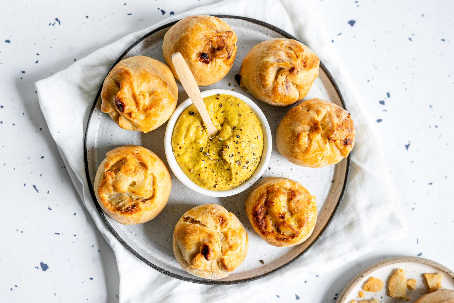 Potato Knishes on a Plate with a Bowl of Mustard