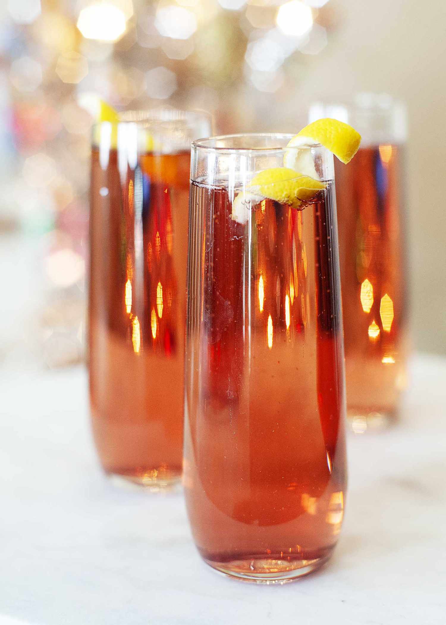 Vue latérale du kir royale dans trois verres hauts et minces sur un fond flou pétillant