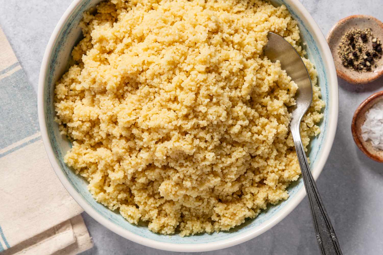 Vue aérienne d'un grand bol de couscous au fromage avec une cuillère de service