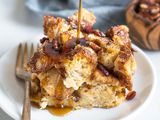 Syrup drizzling onto a French Toast Casserole on white plate with fork