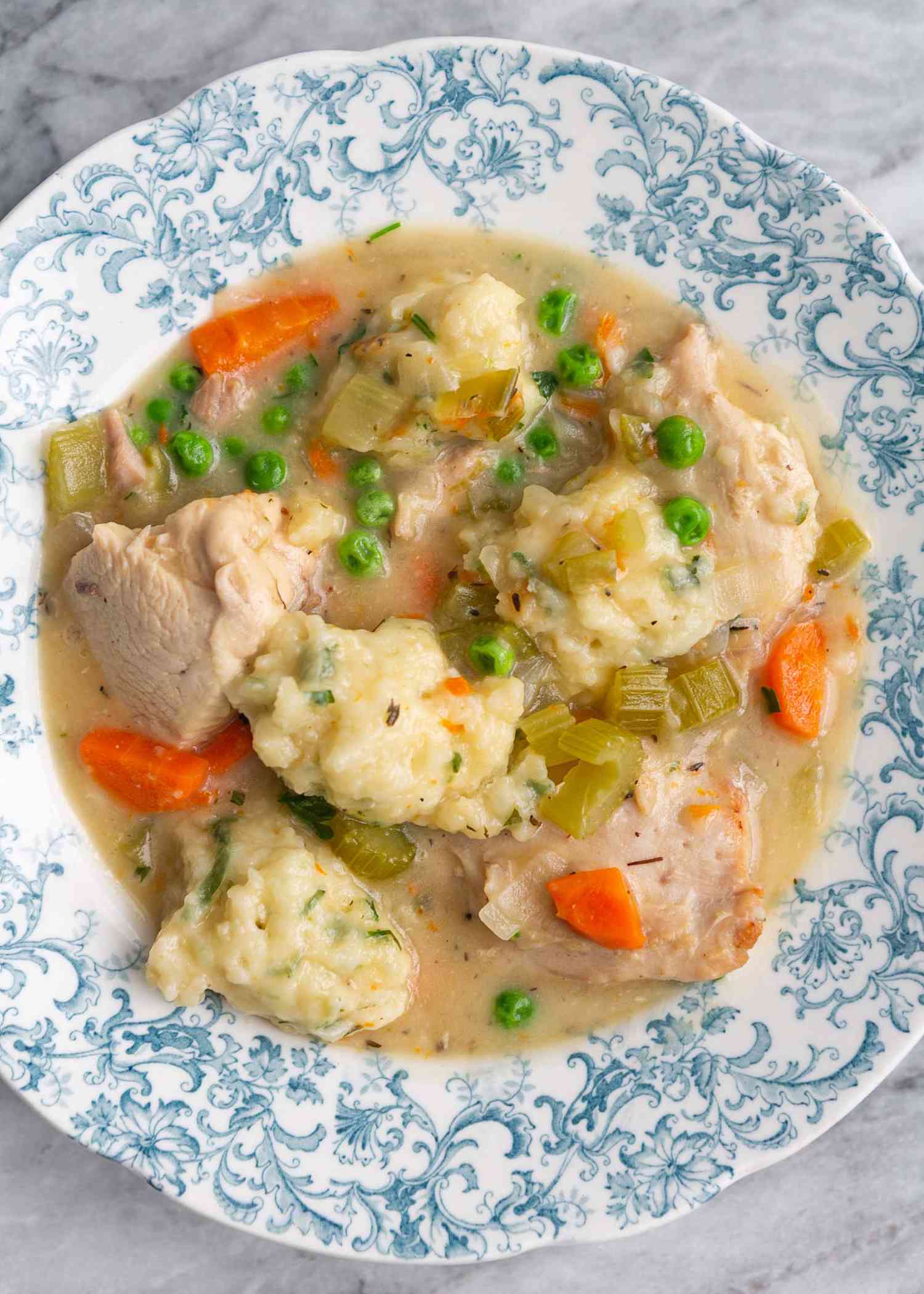 Poulet et dumplings versés dans un bol en porcelaine.