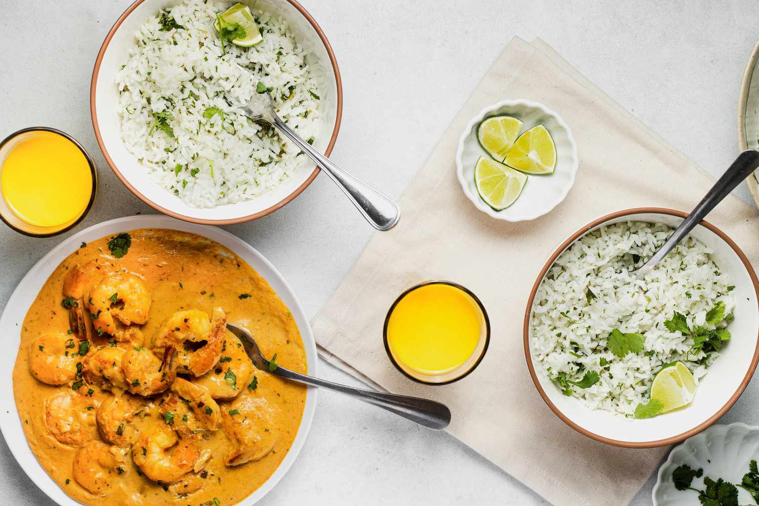 Table Spread with Bowls of Coconut Lime Rice, a Big Bowl of Shrimp Curry, and Glasses of Mango Lassi