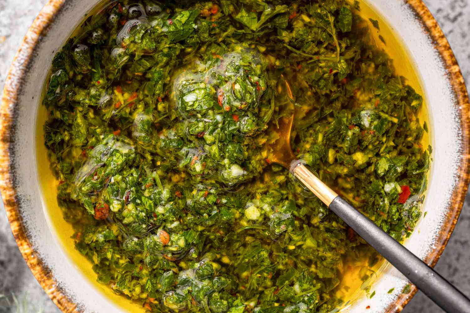 Un bol de chimichurri avec une cuillère