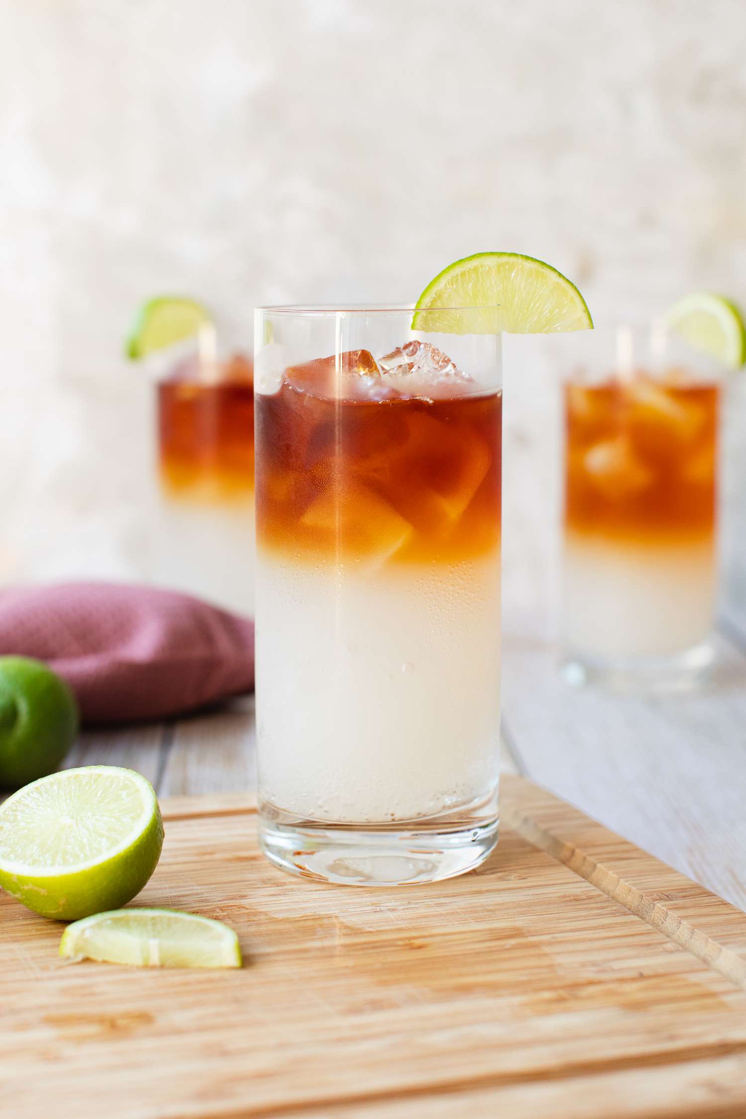 Cocktail Dark and Stormy sur une planche à découper avec des citrons verts