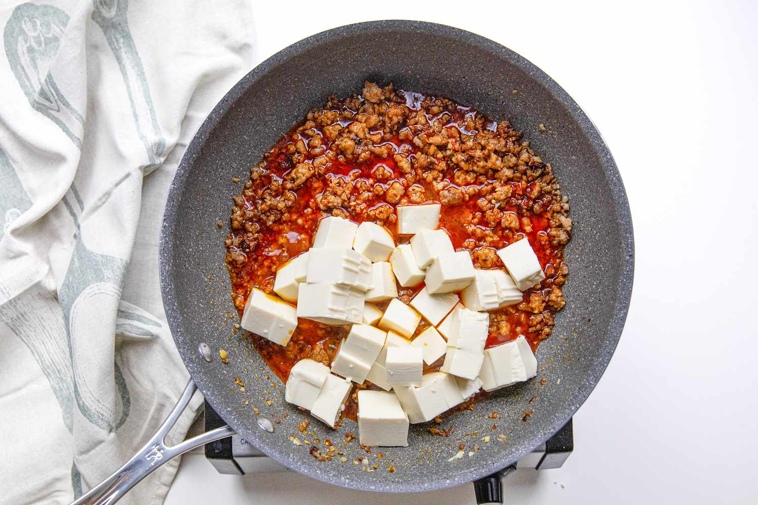 Cubes de tofu et bouillon ajoutés dans la poêle