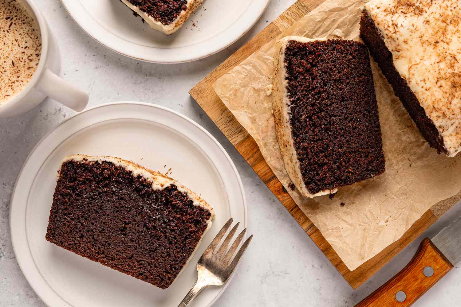 Photo prise de haut d'une part de gâteau au chocolat et stout sur une assiette, à côté du reste du pain sur une planche en bois