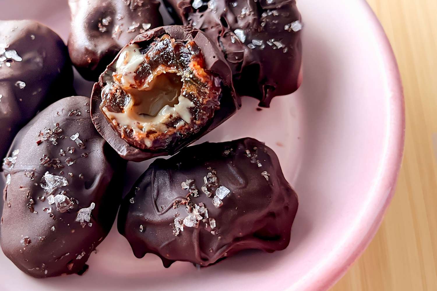 Dattes au tahini et chocolat, l'une coupée en deux sur plusieurs entières dans un bol